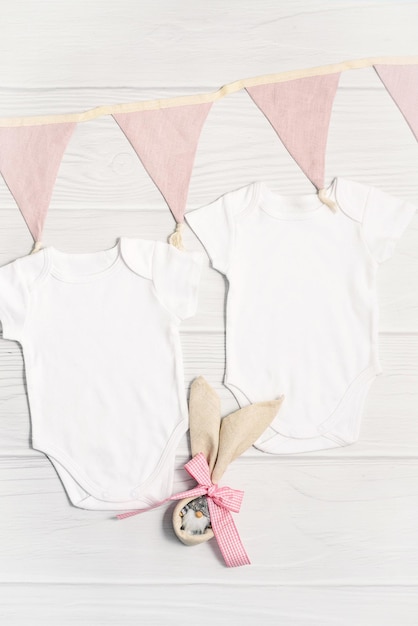 Two white baby bodysuit mockup with Easter decor on white wood