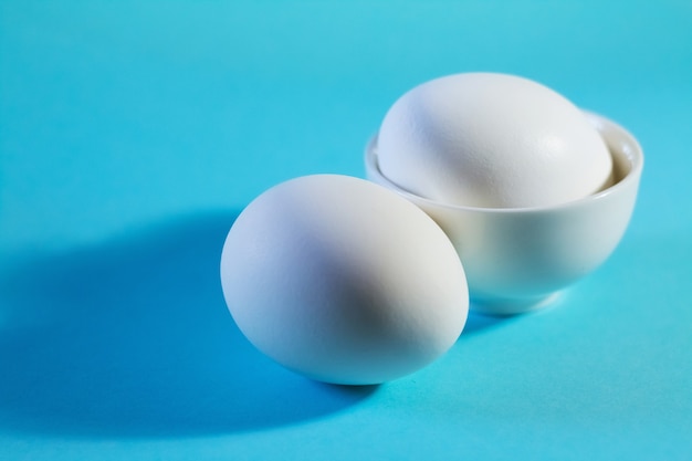 Two white eggs on blue table