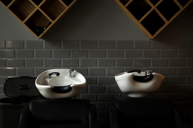 two white sinks for washing hair of a client in a hairdressing salon beauty salon equipment