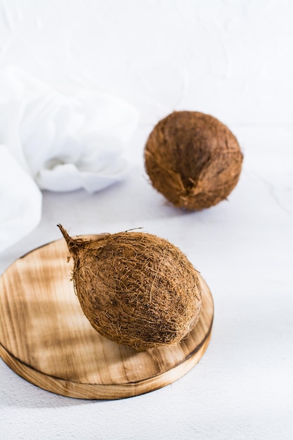 Two whole ripe coconuts on the table Tropical fruits Vertical view