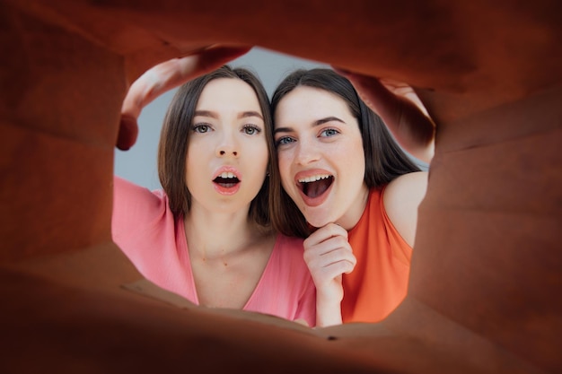 Two woman looking inside cardboard box