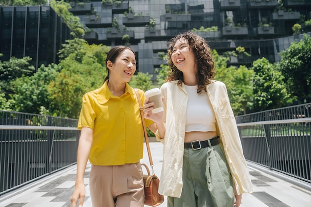 two women are smiling and one has a cup of coffee in her hand