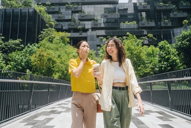 two women are walking in a park one of them has a phone in her hand