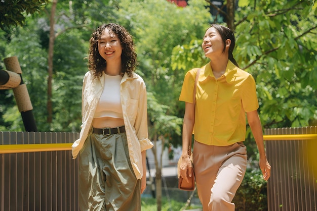 two women are walking in the park one of them has a yellow shirt on