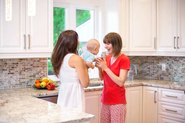  Two women and a child in their arms, the child is given water, a happy family