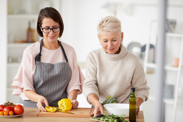 Two women cooking salad