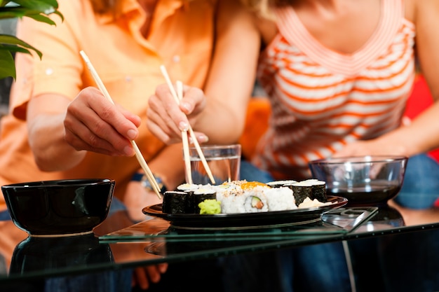 Two women eating sushi