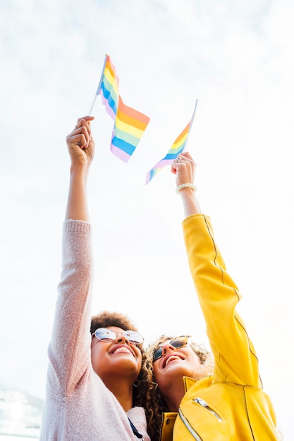 Two women friends hanging out in the city waving LGBT