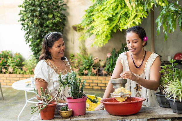 Two Women grinding corn for food Traditional