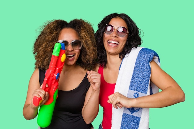 Two women one with Afro hair and the other Latina are ready for a beach vacation in their swimwear