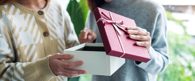 Two women opening a gift box together