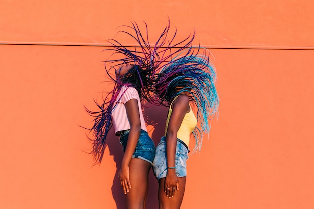 Two women sisters dancing movng hair outdoor