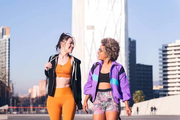 Two women in sportswear talking while walking