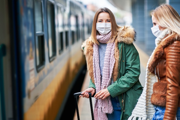 two women at train station wearing masks due to covid-19 restrictions