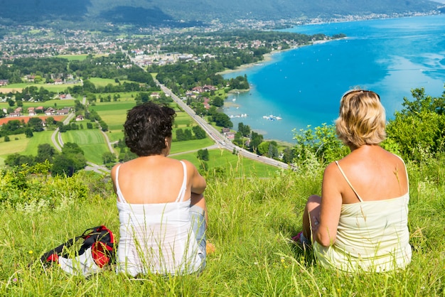 Two women watching view of Lake Annecy