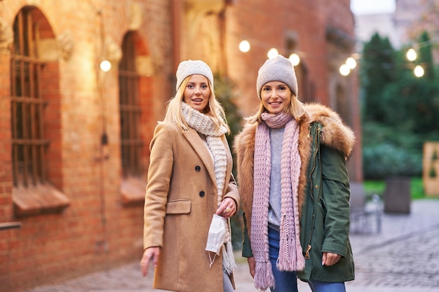 two women wearing face masks and hanging out in the city