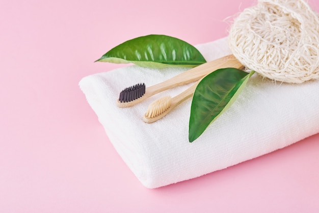 Two wooden bamboo eco friendly toothbrushes, towel and washcloth