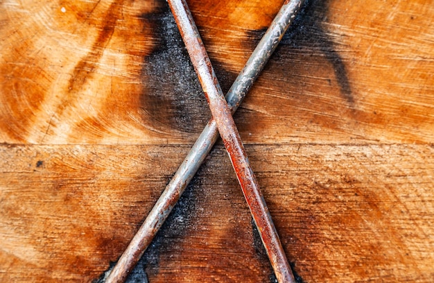 Two wooden beams fastened with steel bars cross to cross closeup