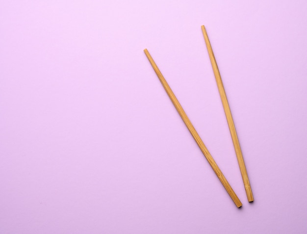 Two wooden chopsticks on purple