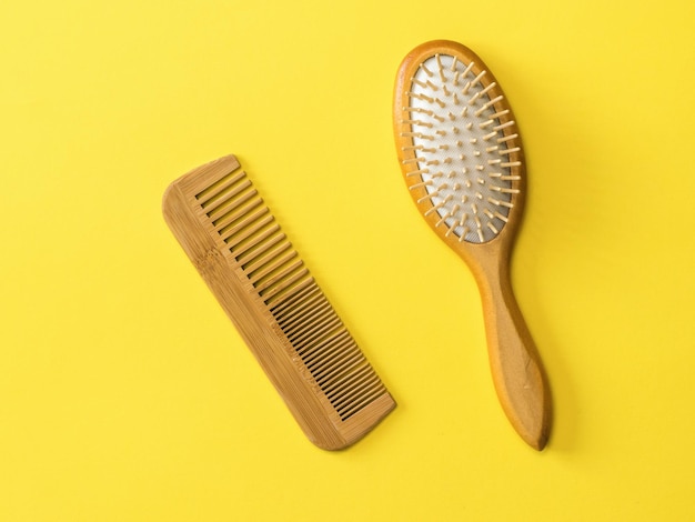 Two wooden combs on a yellow background. Device for combing hair.