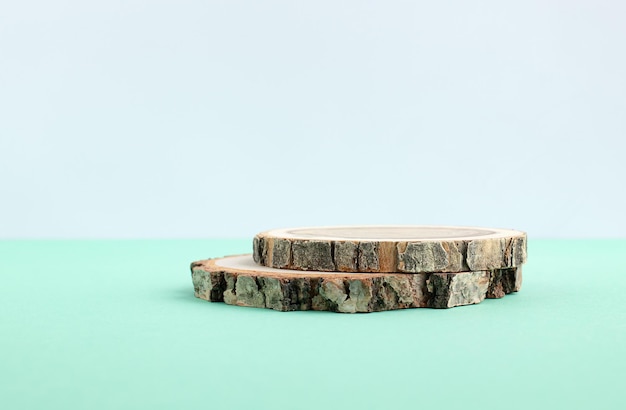 Two wooden discs folded in the form of a podium on a turquoise gray background for the presentation of the product Copy space