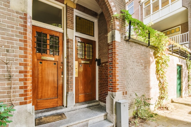 Two wooden doors on a brick house