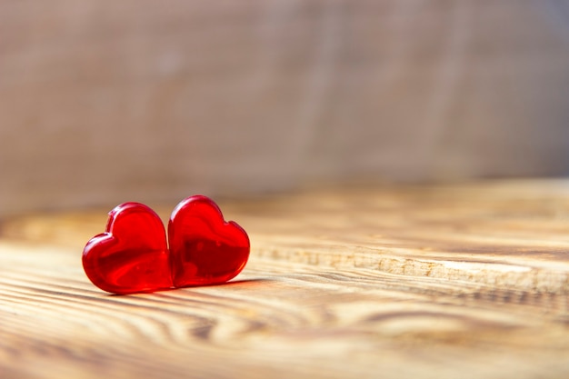 Two Wooden Hearts On Rustic Table With Sunlight
