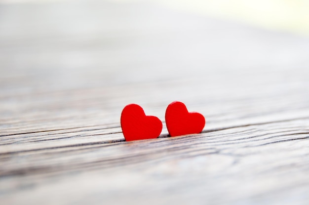 Two wooden hearts on wooden background macro