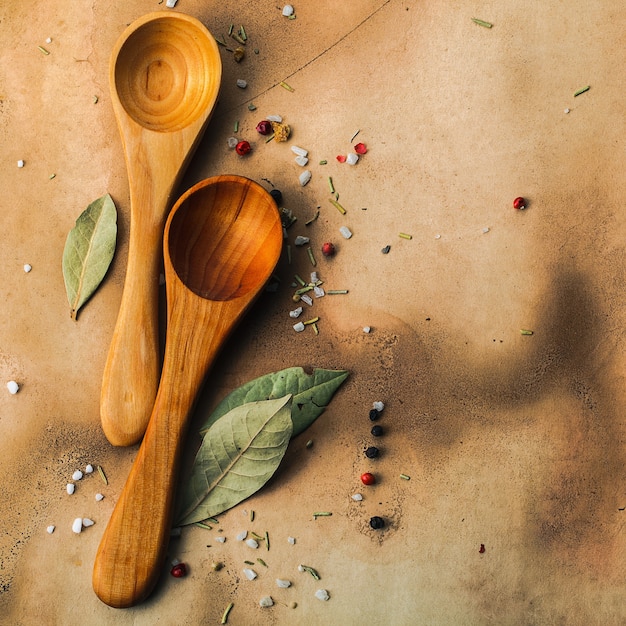 Two wooden spoons, bay leaves, pepper and salt