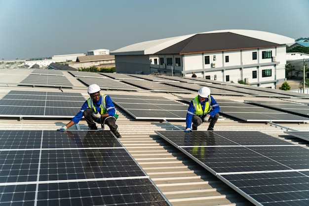 Two workers install solar panels on a roof.