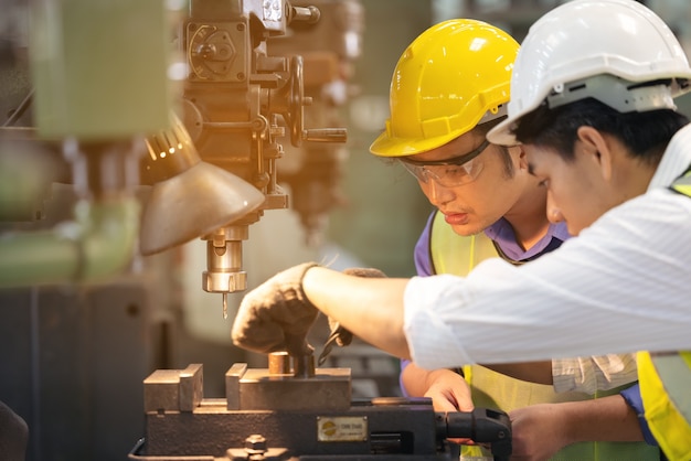 Two workers in production plant as team discussing, industrial scene in background, working together manufacturing activities