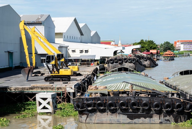 Two yellow backhoe on dock and barges