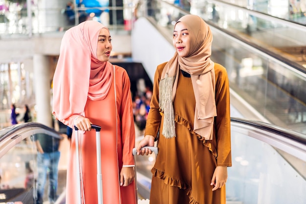 Two young asian fashion muslim woman enjoying shopping time summer sale walk and having fun talking together to buy something in the shop at fashion store