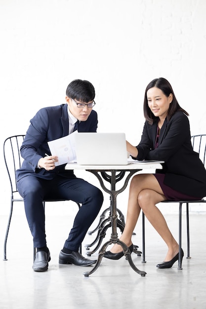 Two young Asian woman and man working with computer laptop Young asian startup small business man and woman happy using laptop Asian Businessman and Businesswoman