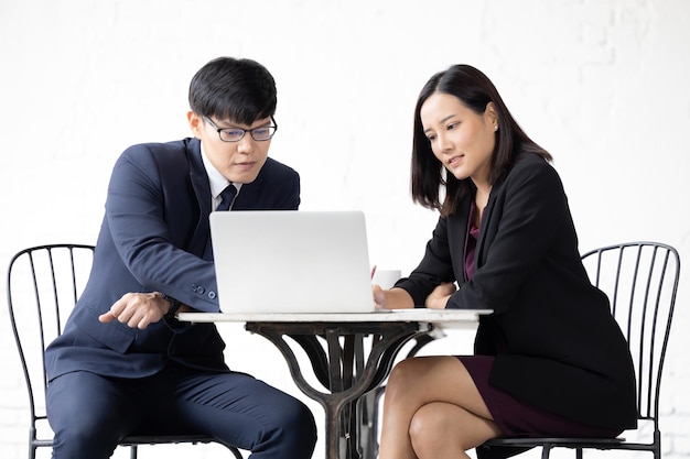 Two young Asian woman and man working with computer laptop Young asian startup small business man and woman happy using laptop Asian Businessman and Businesswoman