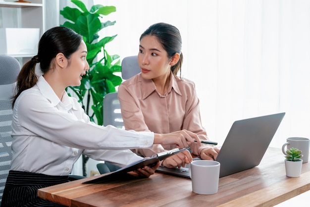 Two young businesswoman work together in office workspace Enthusiastic