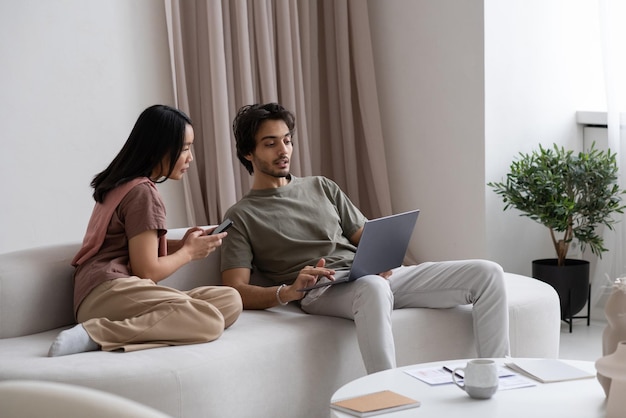 Two young confident employees looking at laptop screen during network