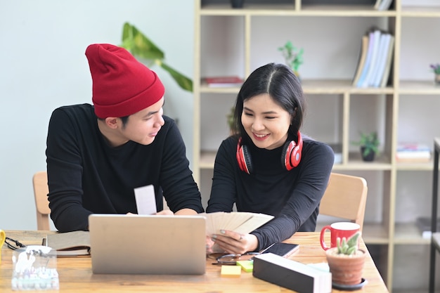 Two young creative designer working on their new project in office.