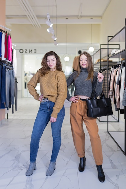 two young female friends rejoice and shop in a clothing store during sales and promotions