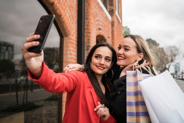 Two young friends taking a selfie with mobile phone.