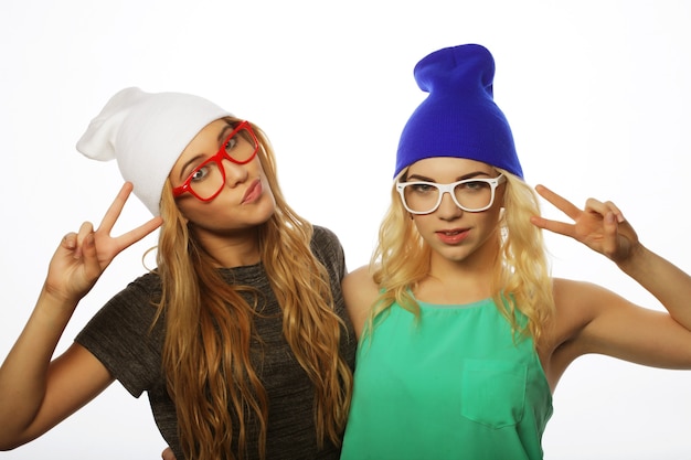 Two young girl friends standing together and having fun.