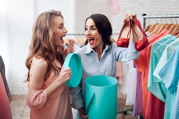 Two young girls choose clothes in the store.