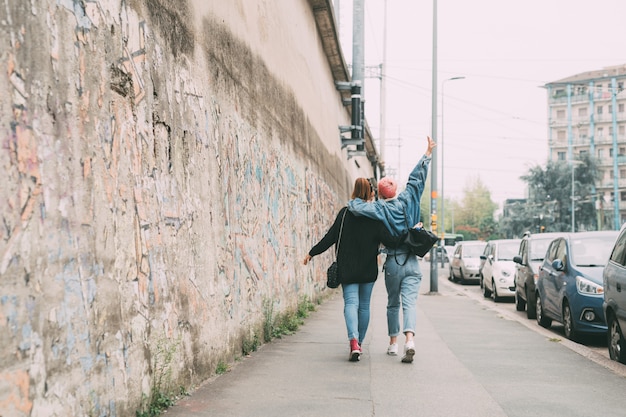 Two young girls outdoor walking hugging