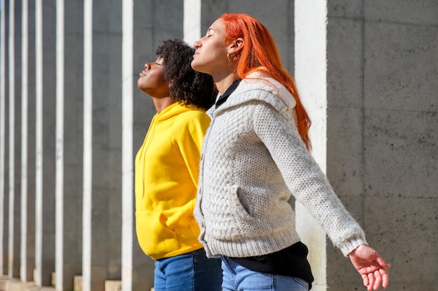 Two young girls taking a deep breath with their eyes closed one black and the other white