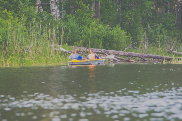 Two young men sailing on the kayak.