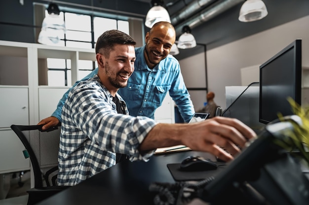 Two young men working together on a new business project in office