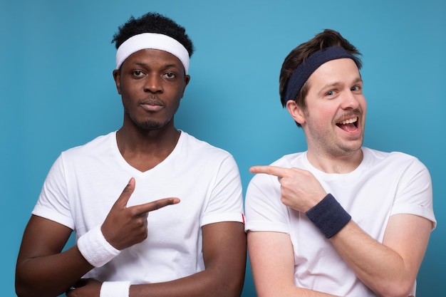 Two young sport men pointing on each other