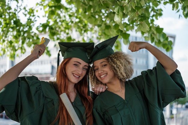 Two young students celebrating their graduation day and finishing their university degree Concept studies education training