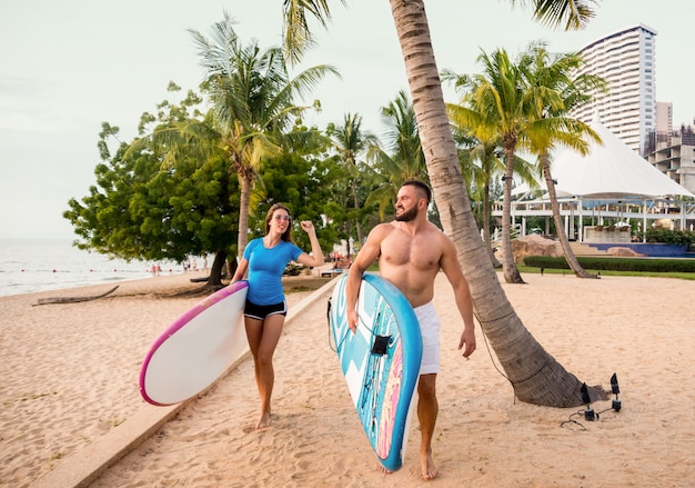 Two young surfers with boards on the beach