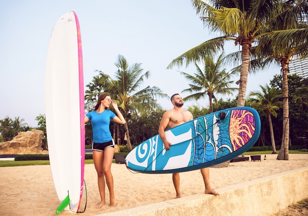 Two young surfers with boards on the beach